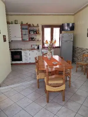 a kitchen with a wooden table and a refrigerator at Endless summer in Castelluzzo