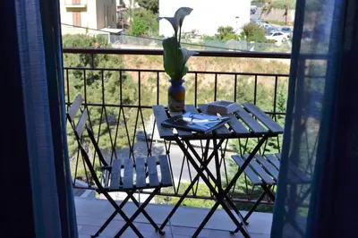a table and chairs on a balcony with a vase at Da Jaco in Castellammare del Golfo