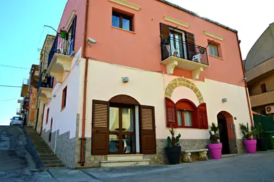 an orange and white building on a street at Casa Vacanze Cappuccini in Castellammare del Golfo