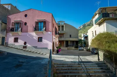 a pink building on the side of a street at Casa Vacanze Cappuccini in Castellammare del Golfo