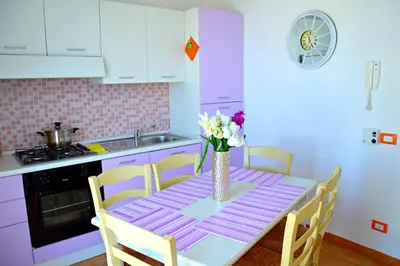 a kitchen with a table with a vase of flowers on it at Casa Vacanze Cappuccini in Castellammare del Golfo