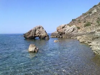 a body of water with some rocks in the water at La Pergola sul mare in Mandra Capreria