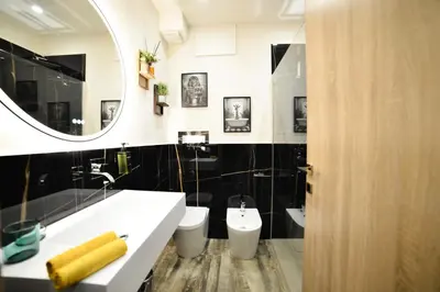 a bathroom with a sink and a toilet and a mirror at Isula SeaView Apartments in Isola delle Femmine