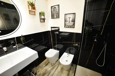 a bathroom with a toilet and a sink and a mirror at Isula SeaView Apartments in Isola delle Femmine