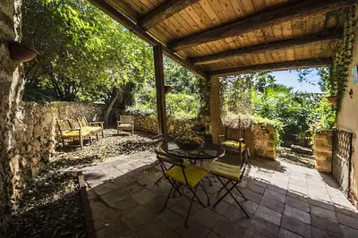 a patio with a table and chairs on a patio at Casa Conigli con piscina condivisa in Terrasini