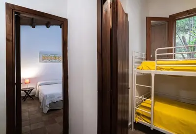 a room with two bunk beds and a mirror at Casa Conigli con piscina condivisa in Terrasini