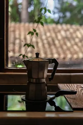 a coffee pot sitting on a table in front of a window at Casa Conigli con piscina condivisa in Terrasini