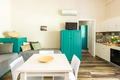 a living room with a white table and a green refrigerator at Ulivo Blu Holiday Homes by Wonderful Italy in Castellammare del Golfo