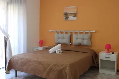 a bedroom with a large bed with orange walls at Casa Chiarenza in Castellammare del Golfo
