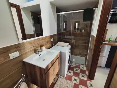 a bathroom with a sink and a washing machine at Palazzo Orangea 1 piano in Bagheria