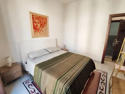 a bedroom with a bed and a picture on the wall at Palazzo Orangea 1 piano in Bagheria