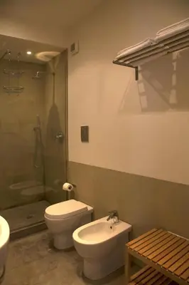 a bathroom with a toilet and a sink and a shower at Rosalmar B&B in Palermo