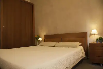 a bedroom with a large bed and a wooden headboard at Rosalmar B&B in Palermo