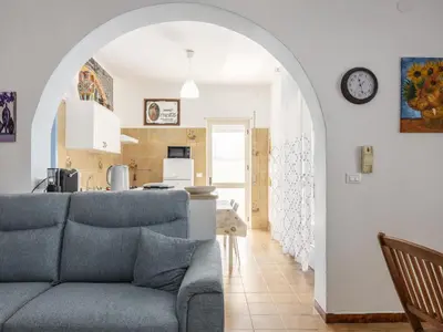 a living room with a blue couch and a kitchen at Apartment Pietra Marina by Interhome in Balestrate