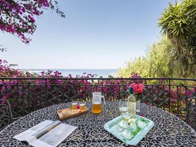 a table with a bottle of wine and a glass at Apartment Cicladi Naxos by Interhome in Santa Flavia