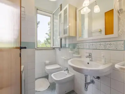 a white bathroom with a sink and a toilet at Apartment Cicladi Naxos by Interhome in Santa Flavia