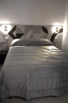 a bedroom with a white bed with two lights at Bom Bom Apartments in Castellammare del Golfo