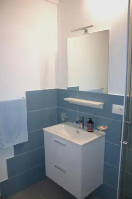 a bathroom with a white sink and a mirror at Bom Bom Apartments in Castellammare del Golfo