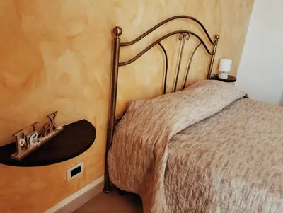 a bedroom with a bed with a wooden wall at Granello di Sabbia in San Vito lo Capo