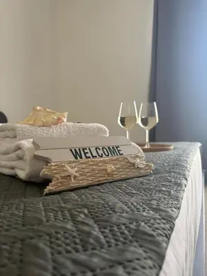 a bed with a welcome sign and two glasses of wine at Granello di Sabbia in San Vito lo Capo