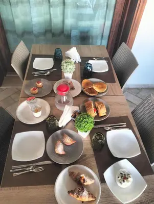 a wooden table with plates of food on it at Granello di Sabbia in San Vito lo Capo