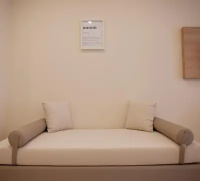 a couch against a white wall with two pillows on it at Balestrate Center Rooms in Balestrate