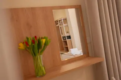 a vase of flowers on a shelf with a mirror at Balestrate Center Rooms in Balestrate