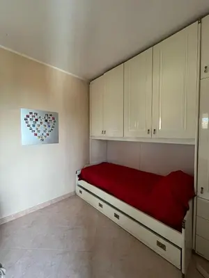 a bedroom with white cabinets and a red bed at Casa Marina in Isola delle Femmine