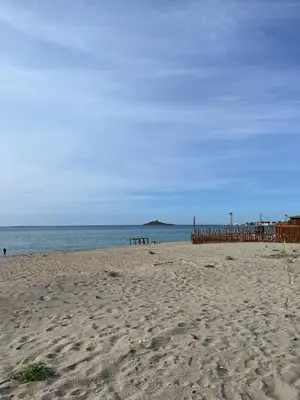 a beach with a wooden pier and the ocean at Casa Marina in Isola delle Femmine