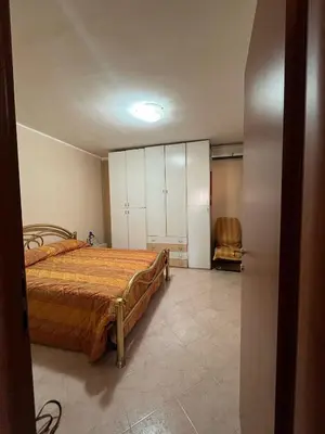 a bedroom with a bed and a chair in it at Casa Marina in Isola delle Femmine