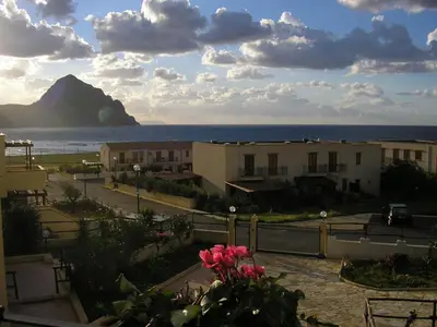 a view of the ocean and buildings and a mountain at Baglio Makari in San Vito lo Capo