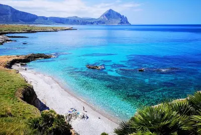 a view of a beach with blue water and mountains at Baglio Makari in San Vito lo Capo