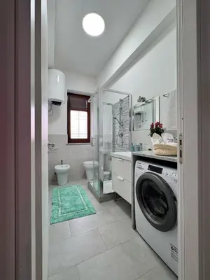 a bathroom with a washer and dryer in it at mamali in Terrasini