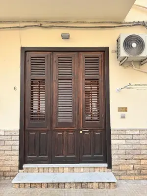 a wooden door on the side of a building at mamali in Terrasini