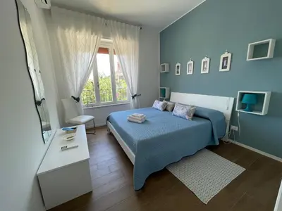 a blue bedroom with a bed and a window at Appartanvilla Magellano in Mondello
