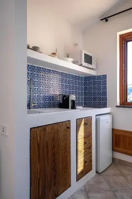 a kitchen with wooden cabinets and a stove top oven at Torre delle mandre in Altavilla Milicia
