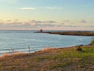 a body of water with a lighthouse in the distance at Da Turiddu in Cinisi