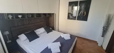 a bedroom with a large bed with white and blue pillows at I Giardini del mare casa vacanza in Buonfornello