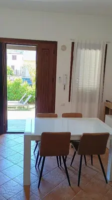 a white table and chairs in a room with a window at I Giardini del mare casa vacanza in Buonfornello