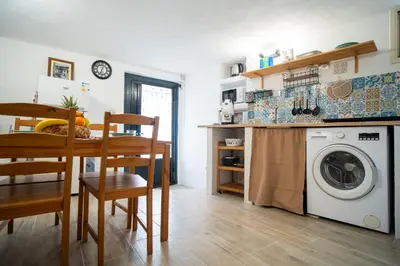 a kitchen with a table and a washing machine at La Casetta di Dandrì in Monreale