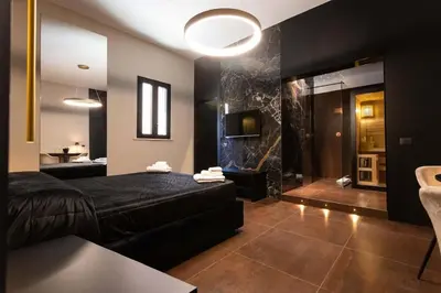a bedroom with a bed and a bathroom with a shower at Black Room Suite and SPA in Carini