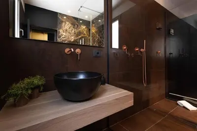 a bathroom with a large black tub on a wooden counter at Black Room Suite and SPA in Carini