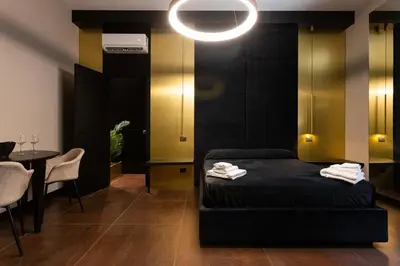 a bedroom with a bed and a table with chairs at Black Room Suite and SPA in Carini