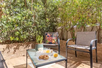 a table and a chair with a tray of donuts and orange juice at Villetta Golfo di Macari 10min San Vito Lo Capo - Horizonte Selections in Castelluzzo
