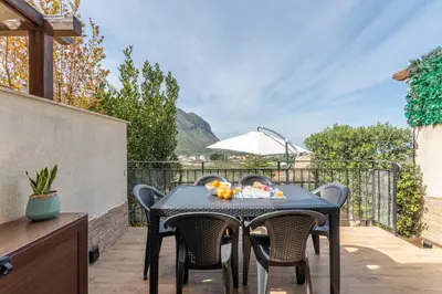 a table and chairs on a patio with a view at Villetta Golfo di Macari 10min San Vito Lo Capo - Horizonte Selections in Castelluzzo