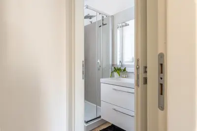 a white bathroom with a sink and a mirror at Villetta Golfo di Macari 10min San Vito Lo Capo - Horizonte Selections in Castelluzzo