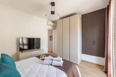 a bedroom with a large bed and a tv at Villetta Golfo di Macari 10min San Vito Lo Capo - Horizonte Selections in Castelluzzo