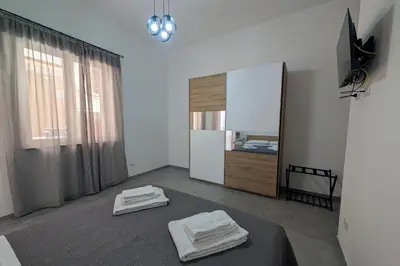 a bedroom with two towels on a bed and a mirror at Nonna Rosa Anna in Isola delle Femmine