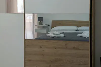 a bedroom with a bed with a mirror at Nonna Rosa Anna in Isola delle Femmine