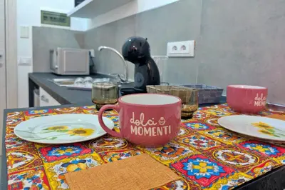 a table with plates and a coffee mug on a table at Nonna Rosa Anna in Isola delle Femmine